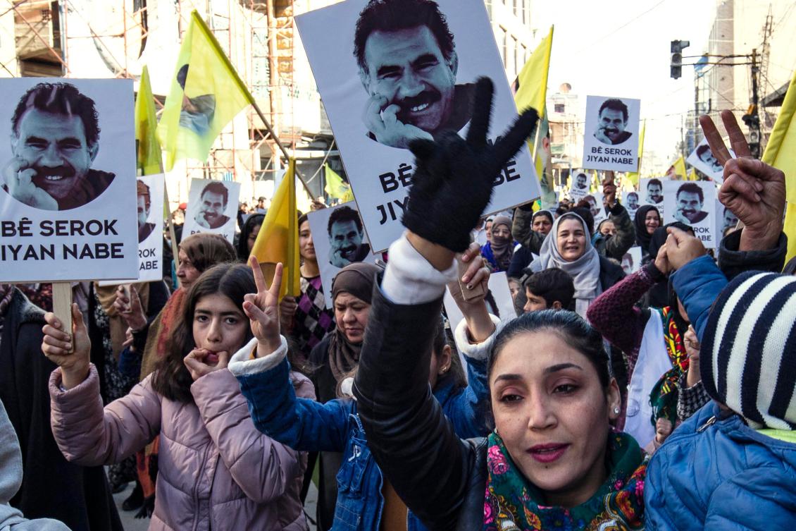 Protesters raise yellow flags and portraits showing the face of Abdullah Ocalan, the leader of the Kurdistan Worker’s Party (PKK) — jailed in Turkiye since 1999 — during a demonstration calling for his release, in the Kurdish-majority city of Qamishli in northeastern Syria on February 15, 2023. (AFP)