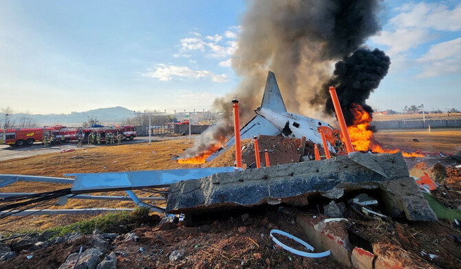 Firefighters carry out extinguishing operations on an aircraft which drove off runaway at Muan International Airport in Muan, South Korea, on December 29, 2024. (REUTERS)