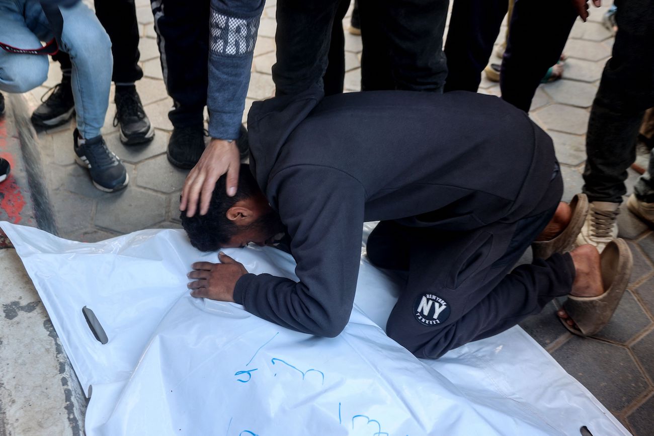 A man mourns over the body of a loved one killed in an Israeli strike on Al-Meghazi refugee camp in the Gaza Strip, at the Aqsa Martyrs hospital in Deir El-Balah on December 28, 2024. (AFP)