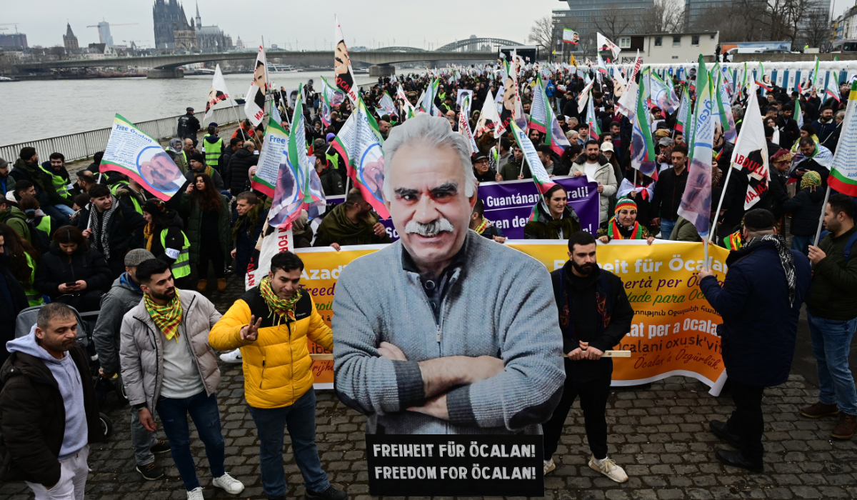 Supporters of the Kurdish community demonstrate with flags and banners on the occasion of the 25th anniversary of the arrest of Kurdistan Workers Party (PKK) leader Abdullah Ocalan on the banks of the Rhine river in Cologne, western Germany, on February 17, 2024. (AFP)