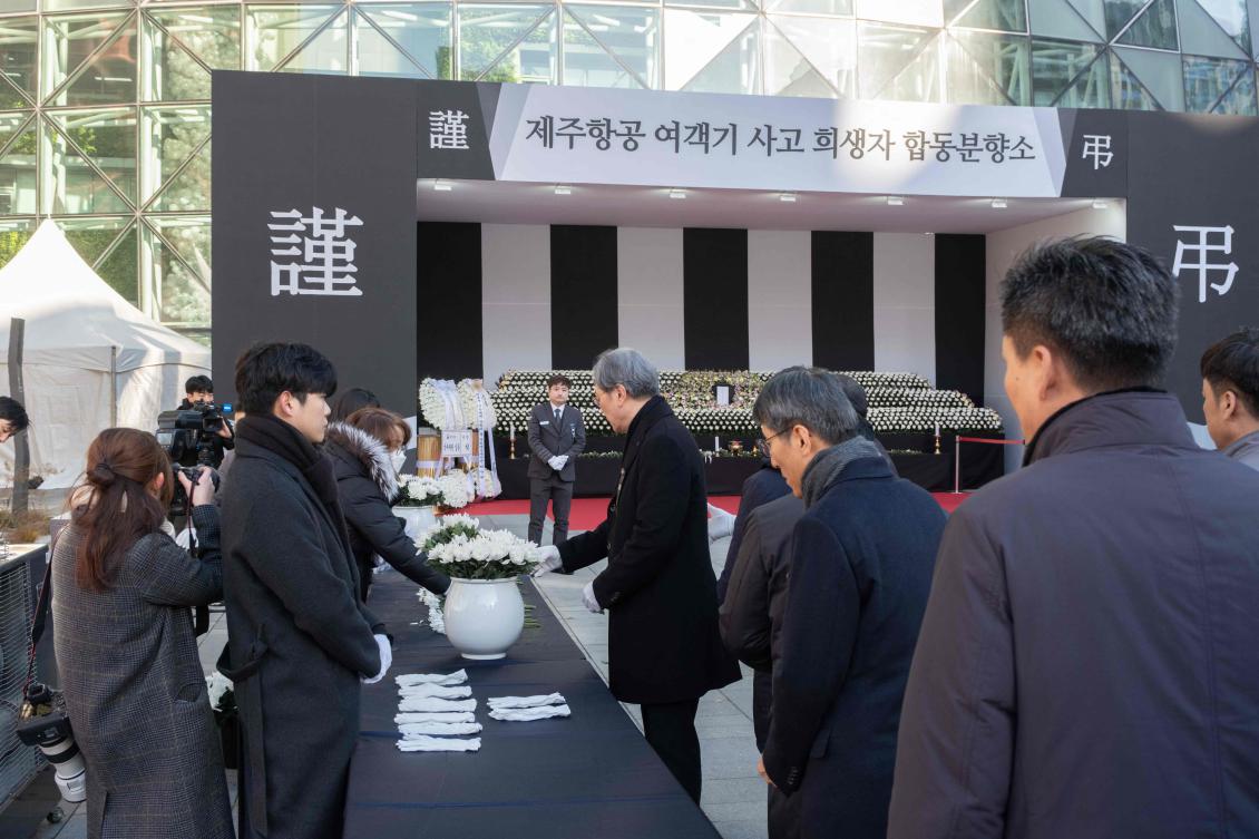 South Korea is observing seven days of mourning, with flags flying at half-mast. Above, people collect flowers before placing them in front of the memorial set up in front of Seoul City Hall on Dec. 31, 2024. (AFP)