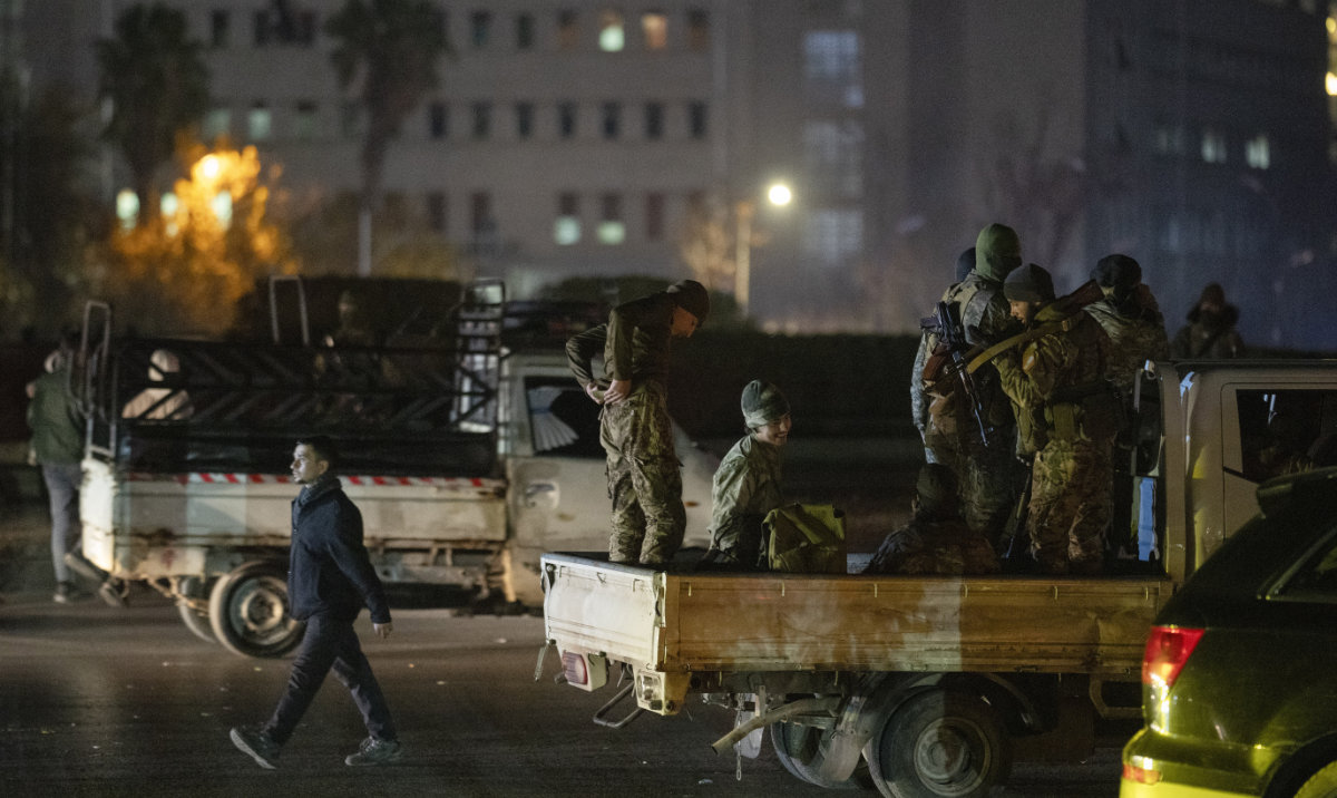 Syrian fighters stand on vehicle parked on a street at the central square in Damascus, Syria, Dec. 25, 2024. (AP)