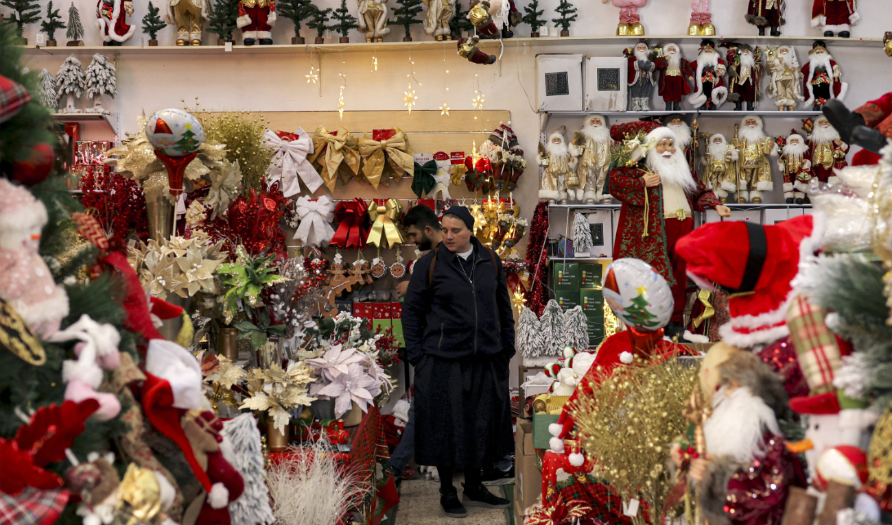 A nun browses items at a shop selling Christmas decorations and accessories in Bethlehem. (AFP)