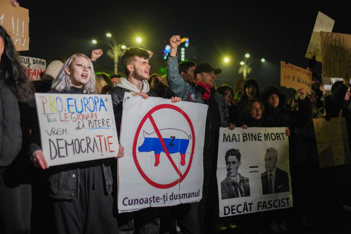 Protesters hold banners saying "Better dead than a fascist" and "Know your enemy", during a demonstration in Bucharest, Romania, on November 27, 2024, against Calin Georgescu, the independent presidential candidate who made it to the runoffs. (REUTERS)