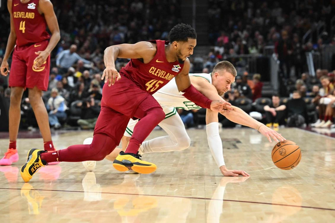 Donovan Mitchell of the Cleveland Cavaliers and Kristaps Porzingis of the Boston Celtics dive for a loose ball during their NBA game on Dec. 01, 2024 in Cleveland, Ohio. (Getty Images via AFP)