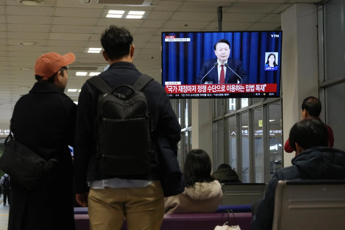People watch a TV screen showing South Korean President Yoon Suk Yeol’s televised briefing at a bus terminal in Seoul, Dec. 3, 2024. (AP)
