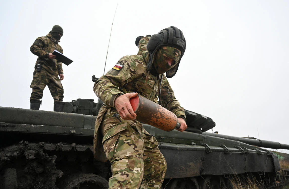 A Russian contract soldier listens to instructions of an officer while training near a T-72 tank during military drills in the southern Krasnodar region, Russia. (Reuters)