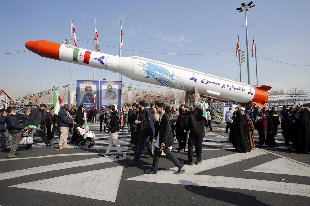 Above, Iran’s two-stage Simorgh satellite carrier is displayed in Tehran as people gather to mark the 45th anniversary of the Islamic revolution on Feb. 11, 2024. (AFP)
