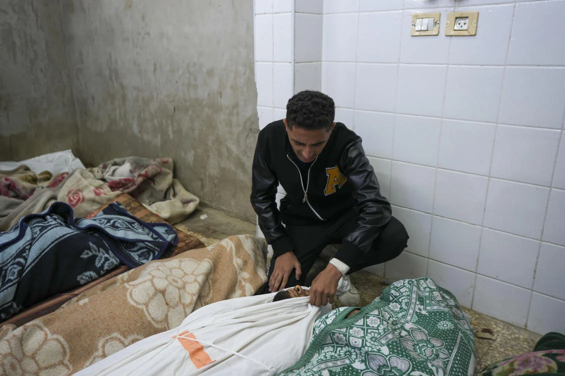 A Palestinian man mourns over the body of a victim following an Israeli bombardment, at the morgue of Al-Aqsa Martyrs hospital in Deir Al-Balah, Gaza Strip, Sunday, Dec. 8, 2024. (AP)