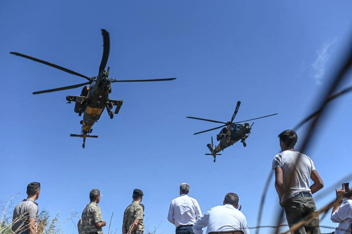 FILE: Turkish helicopters fly over Turkish soldiers and journalists as US and Turkish armoured vehicles take part in their first joint patrol with Turkey under a deal reached between Washington and Ankara, at the border with Syria near Akcakale, in the Sanliurfa province of Turkey, on September 8, 2019. (AFP)