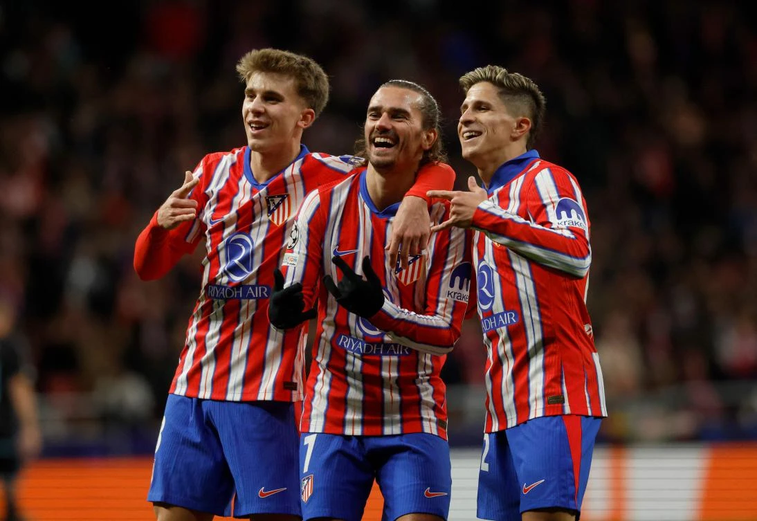 Atletico Madrid’s French forward Antoine Griezmann celebrates scoring his team’s second goal, with Spanish midfielder Pablo Barrios and Argentine forward Giuliano Simeone during their UEFA Champions League match against Slovan Bratislava at the Metropolitano stadium in Madrid on Dec. 11, 2024. (AFP)
