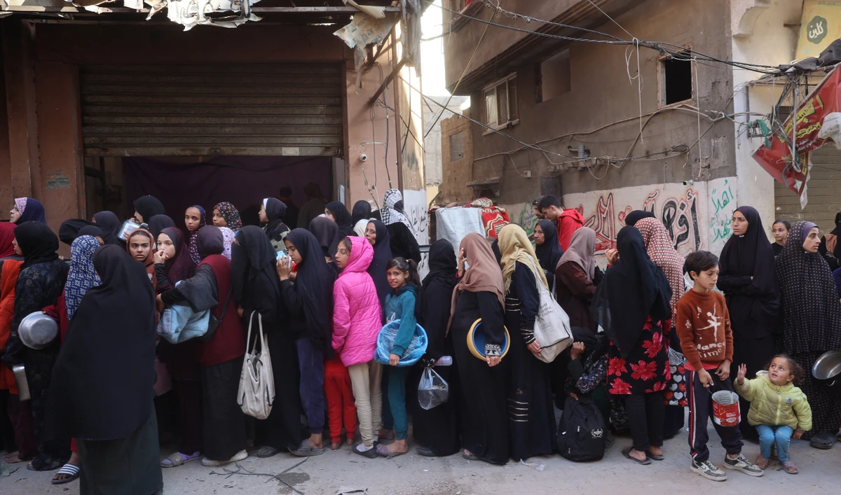 Palestinians wait for food aid outside a distribution centre at the Nuseirat refugee camp in the central Gaza Strip on December 4, 2024. (AFP)