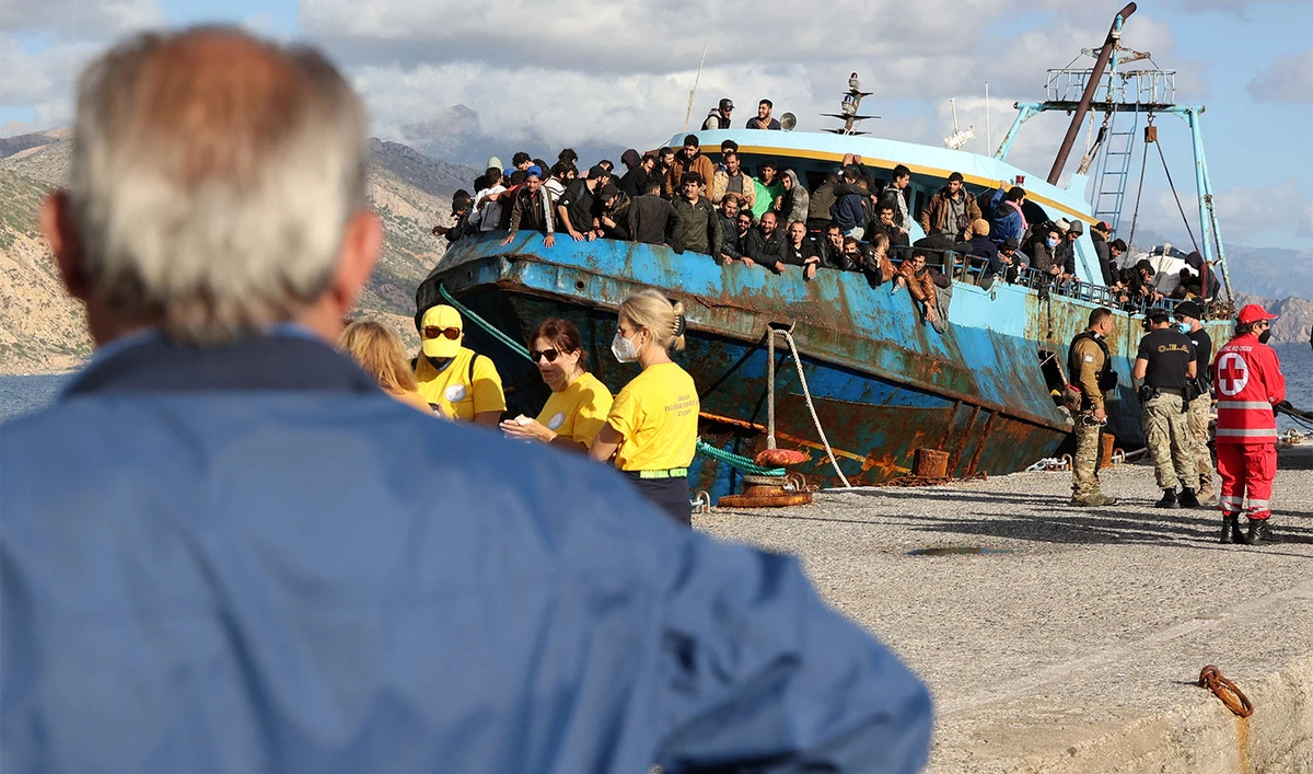 Rescued refugees and migrants stand aboard a boat at the town of Paleochora, southwestern Crete island on November 22, 2022. (AFP/File)