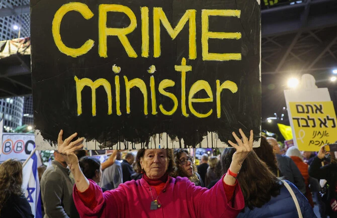 Demonstrators raise placards and Israeli flags during an anti-government protest calling for action to secure the release of Israeli hostages held captive since the October 2023 in the Gaza Strip, in front of the Israeli Defence Ministry in Tel Aviv on December 14, 2024. (AFP)