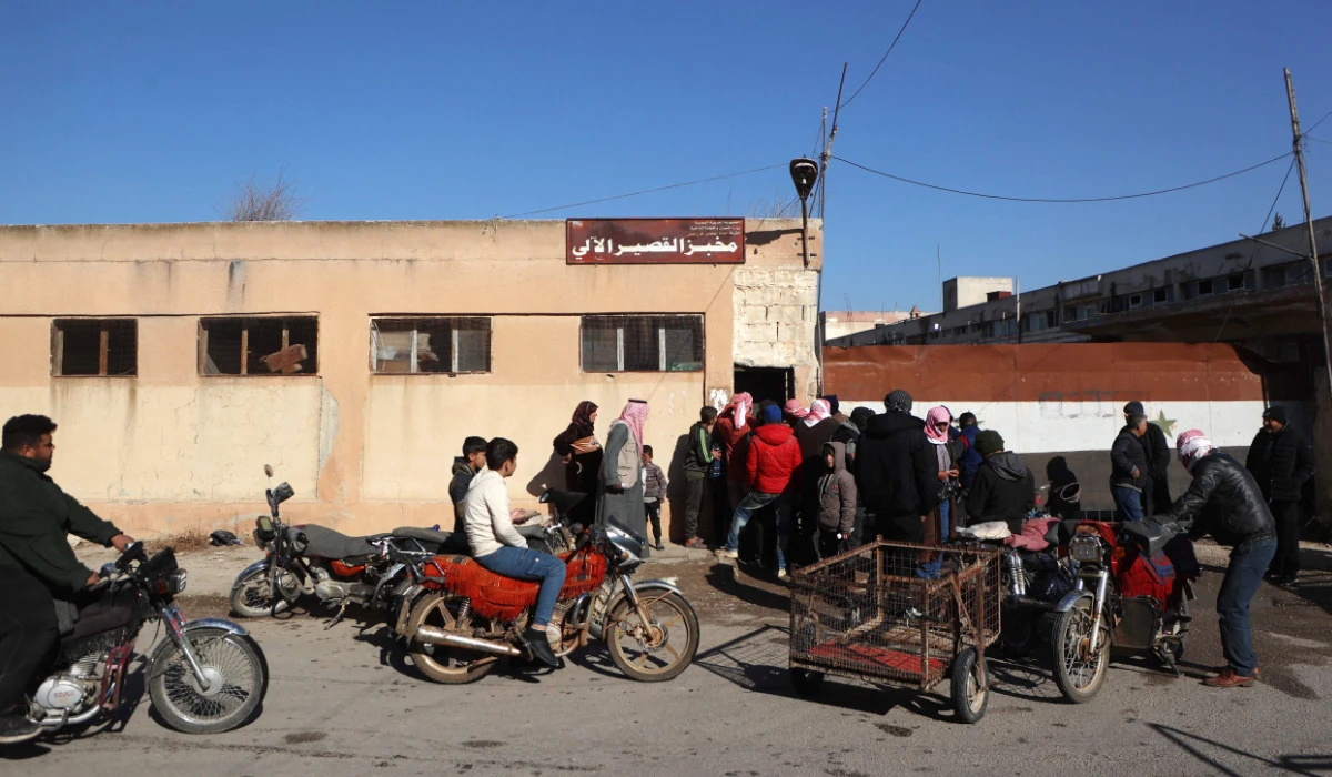 Syrians queue to buy bread from a bakery in the town of in Qusayr in Syria's central Homs province on December 14, 2024. (AFP)