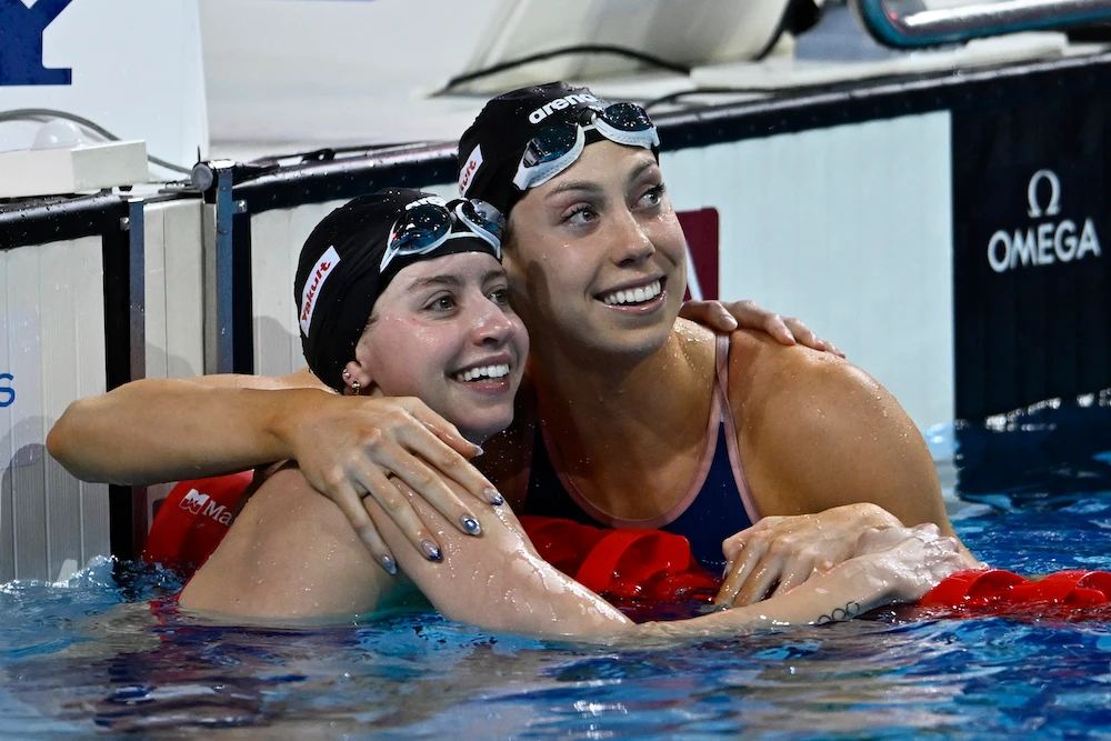 Second-placed Kate Douglass, left, and first-placed Gretchen Walsh, both from the US, look at the scoreboard after the 50-meter freestyle final at the World Short Course Swimming Championships in Budapest Sunday. (AP)
