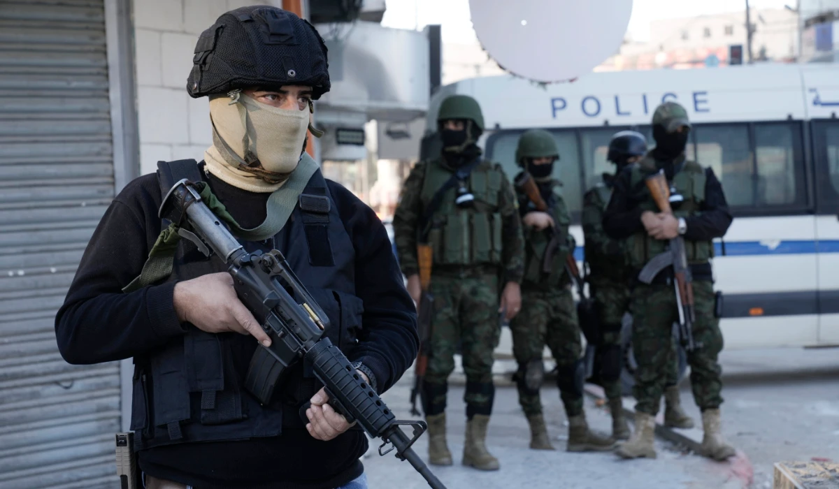 A officer from the Palestinian Authority clutches his gun as Palestinian security forces mount a major raid against militants in the Jenin refugee camp in the Israeli-occupied West Bank, Monday, Dec. 16, 2024. (AP)