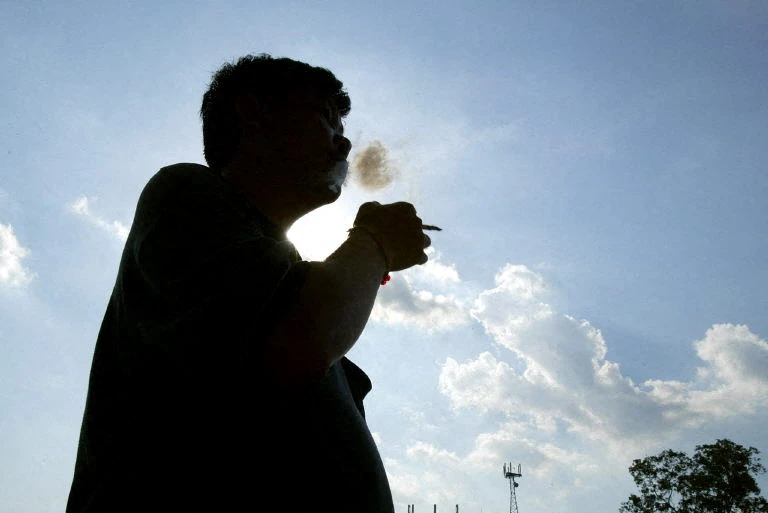 A man smokes a cigarette in Kuala Lumpur, 18 May 2004. (AFP)