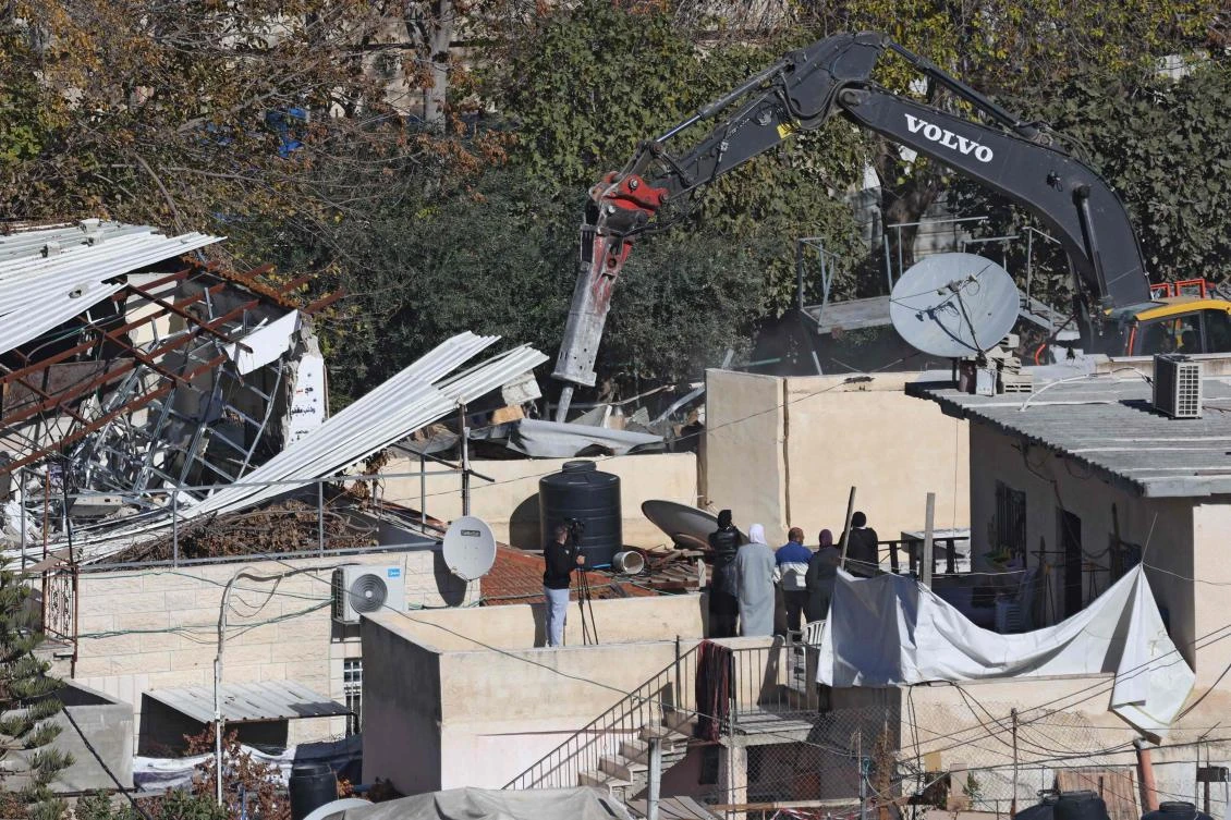 An excavator of the Israeli forces demolishes a house belonging to the Palestinian Abu Diab family in the al-Bustan neighbourhood of the Arab town of Silwan in Israel-annexed east Jerusalem on December 16, 2024. (AFP)