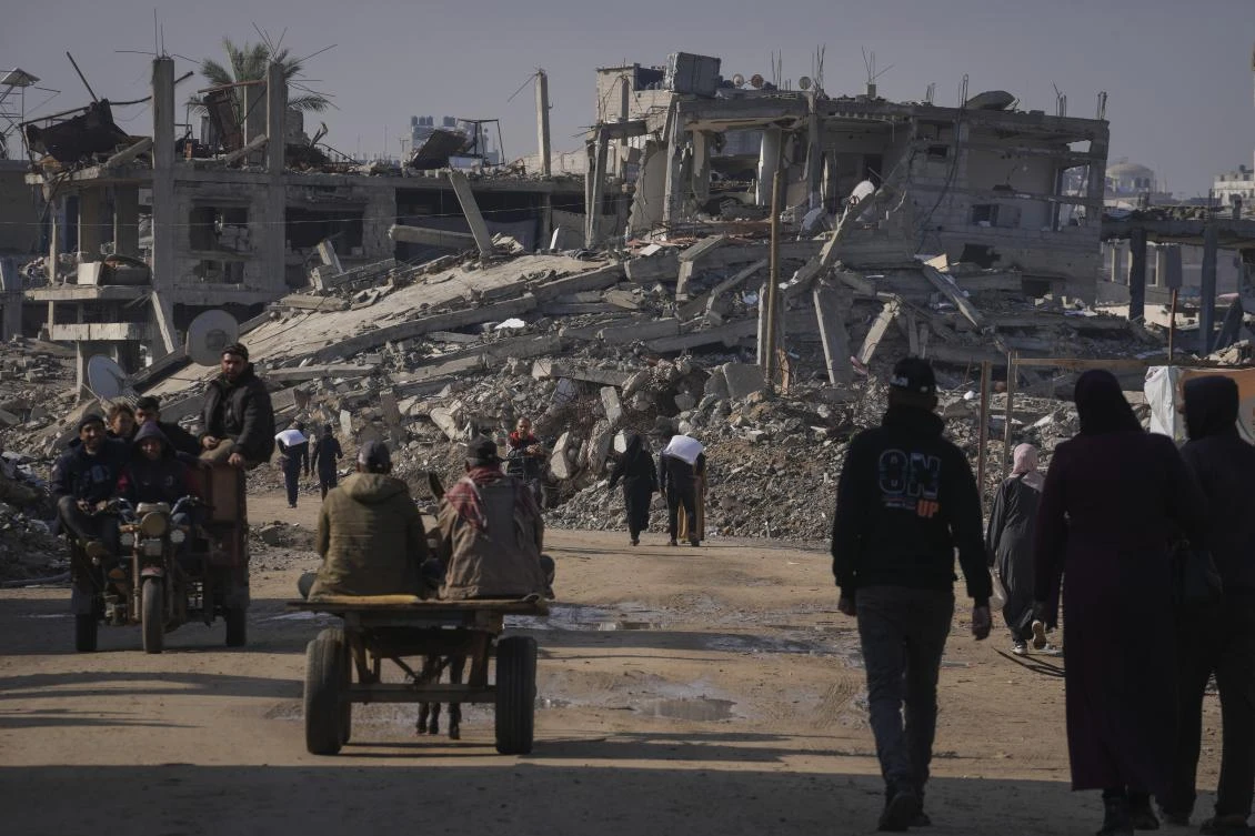 Palestinians carry UN-donated flour in Khan Younis, central Gaza Strip. (File/AP)