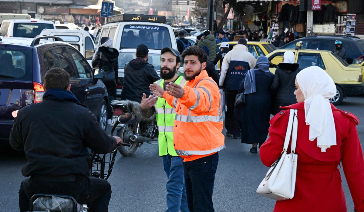 Syrian volunteers help police regulate traffic in Damascus on December 19, 2024. (AFP)