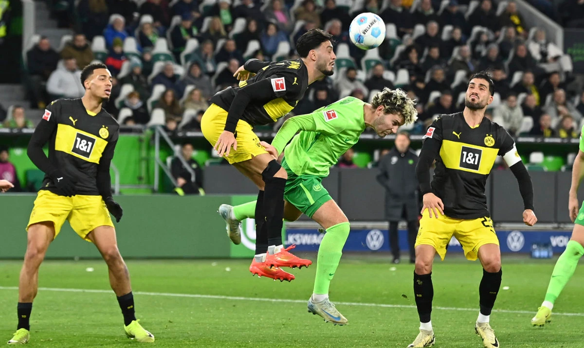 Dortmund holds on with 10 men for 1st away win in Bundesliga