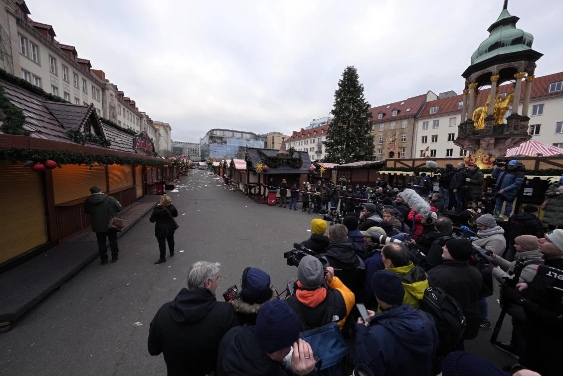 Journalists wait for the arrival of the Chancellor of Germany Olaf Scholz at Christmas Market, where a car drove into a crowd on Friday evening, in Magdeburg, Germany, Saturday, Dec. 21, 2024. (AP Photo/Michael Probst)