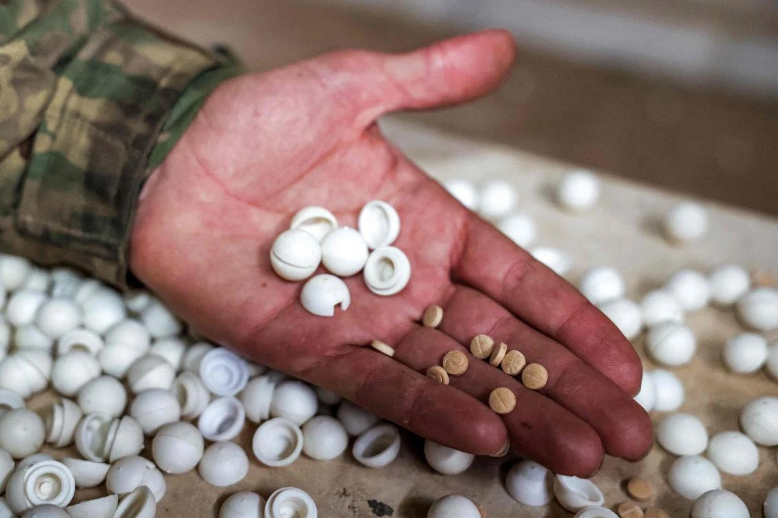 A Syrian rebel fighter inspects pills of Captagon (brand name of psychostimulant drug Fenethylline) produced at a makeshift lab facility at a ranch villa in the town of Al-Dimas about 27 kilometers northwest of Damascus on December 22, 2024. (AFP)