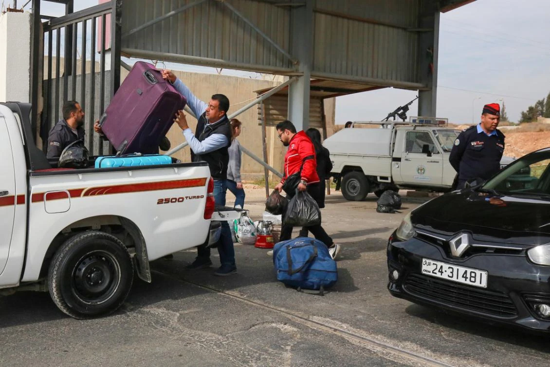 Syrians wait to cross through Jordan's Jaber crossing and into Syria on December 8, 2024, following the fall of the Syrian regime in Damascus. Jordanian police officers check the documents of Syrians returning to their country through the ـJaber border crossing on December 8, 2024. (AFP)