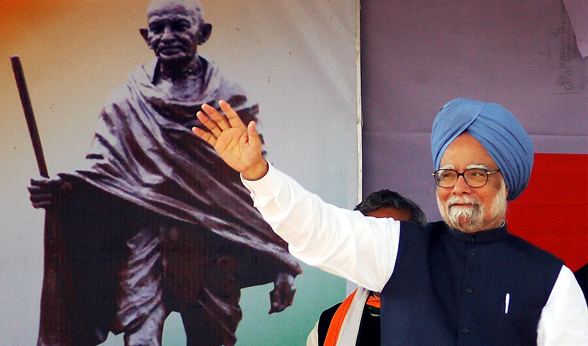 Former Indian Prime Minister Manmohan Singh waves to Congress Party supporters during a public rally in Udaipur, India, on February 19, 2008. (AFP/File)
