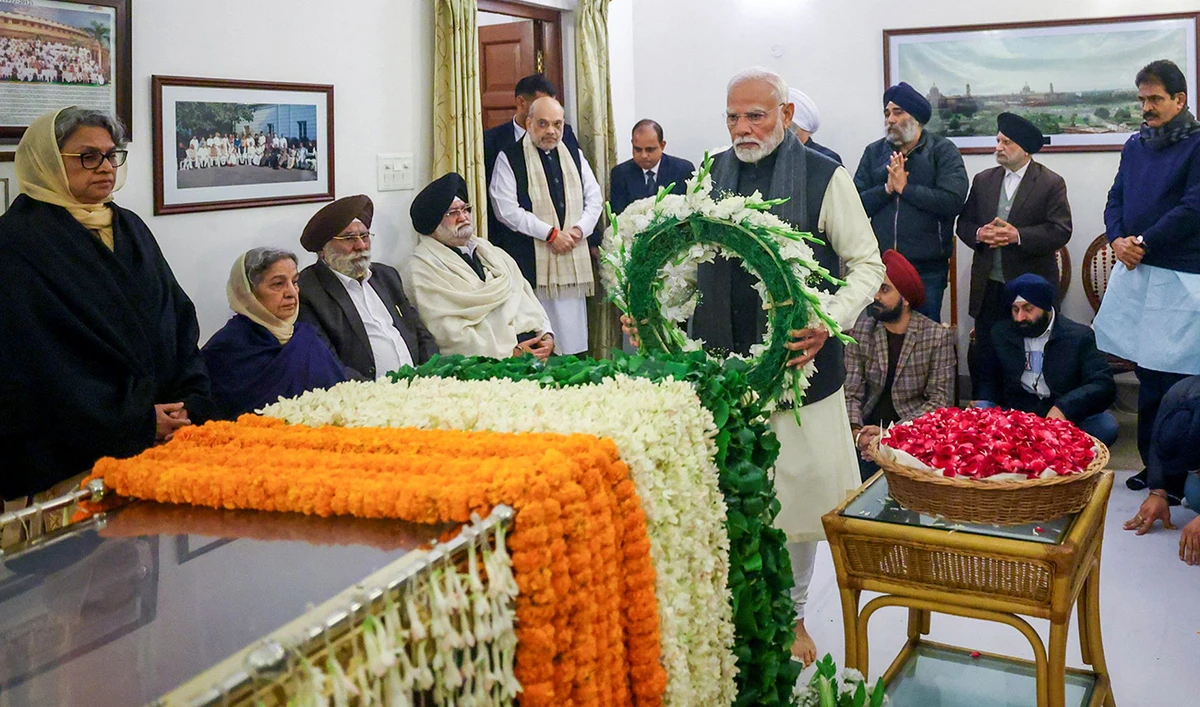 In this handout photograph taken on December 27, 2024 and released by the Indian Press Information Bureau (PIB), India’s Prime Minister Narendra Modi (C) lays a wreath as he pays last respects to former Indian Prime Minister Dr. Manmohan Singh at his residence in New Delhi. (AFP)