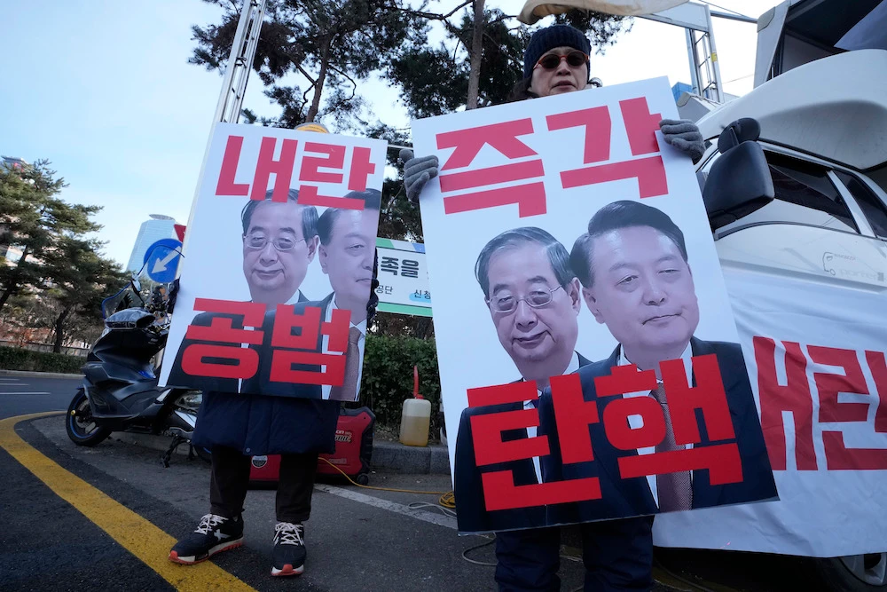 Protesters hold banners showing images of impeached President Yoon Suk Yeol, right, and acting President Han Duck-soo during a rally in Seoul, South Korea on Dec. 27, 2024. (AP)
