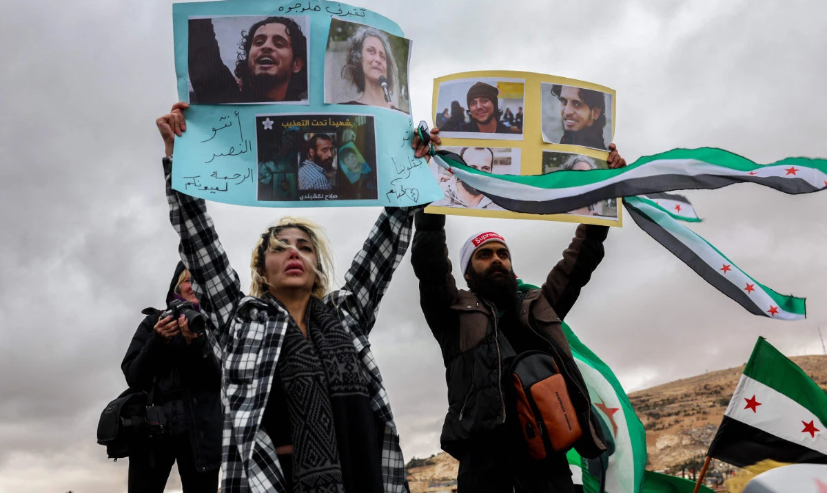 People hold pictures of missing persons during a demonstration celebrating the fall of Syrian president Bashar Al-Assad at Ummayad Square in the capital Damascus on December 27, 2024. (AFP)