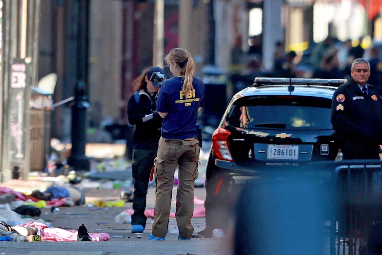 A member of the FBI’s Evidence Response Team takes photographs near a pair of bodies on Bourbon Street after a car ramming in New Orleans, Louisiana. (AFP)