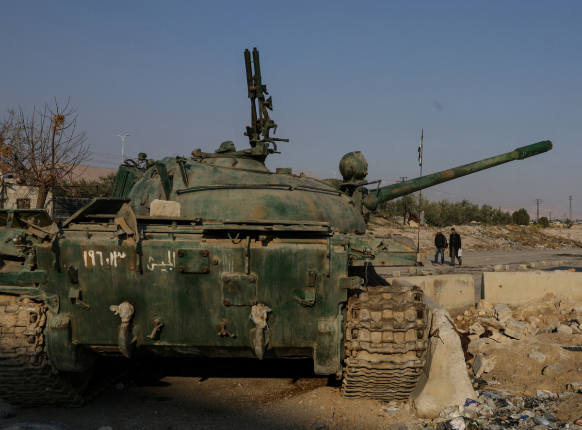 Men walk near an abandoned tank that belongs to the ousted Syrian President Bashar al-Assad's forces, on the outskirts of Damascus, Syria, on January 2, 2025. (REUTERS)