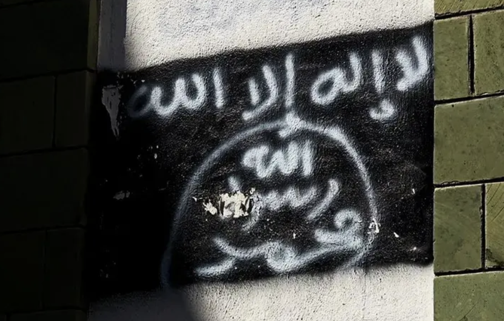 Black Al-Qaeda flag is sprayed on the wall of a damaged school in Taiz in 2017. (AP/File Photo)