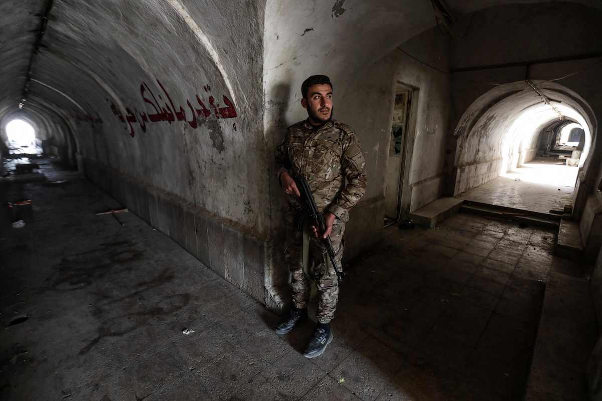 A fighter affiliated with Syria's new administration stands inside a tunnel, inside the abandoned Syrian Republican Guard base near Damascus on Jan. 4. (AFP)