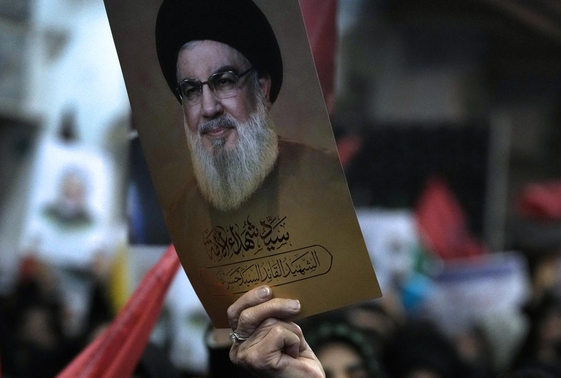 A woman holds up a poster of the slain Hezbollah leader Hassan Nasrallah during a ceremony marking death anniversary of the late commander of the Iran’s Revolutionary Guard expeditionary Quds Force, Gen. Qassem Soleimani, in Tehran, Iran, Thursday, Jan. 2, 2025. (AP)