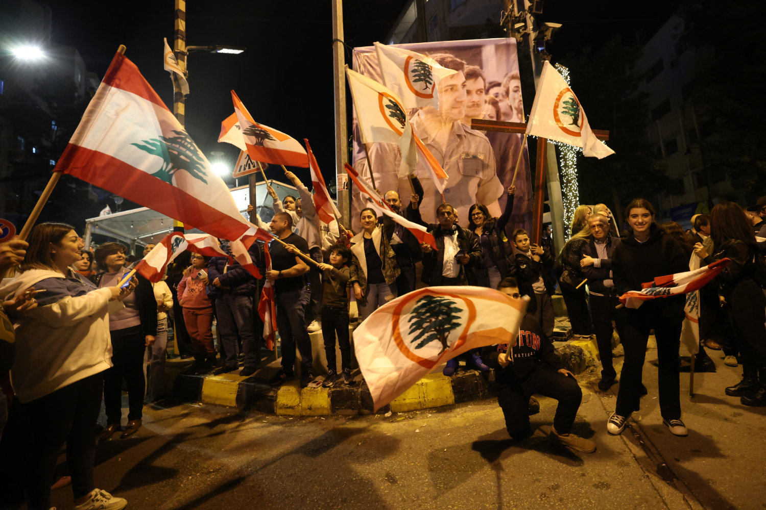 Supporters of the Christian Phalange party and the Lebanese Forces Party gather to celebrate in Beirut's neighborhood of Achrafieh on December 8, 2024, after Syrian opposition forces declared that they have taken Damascus from the Assad regime. (AFP)