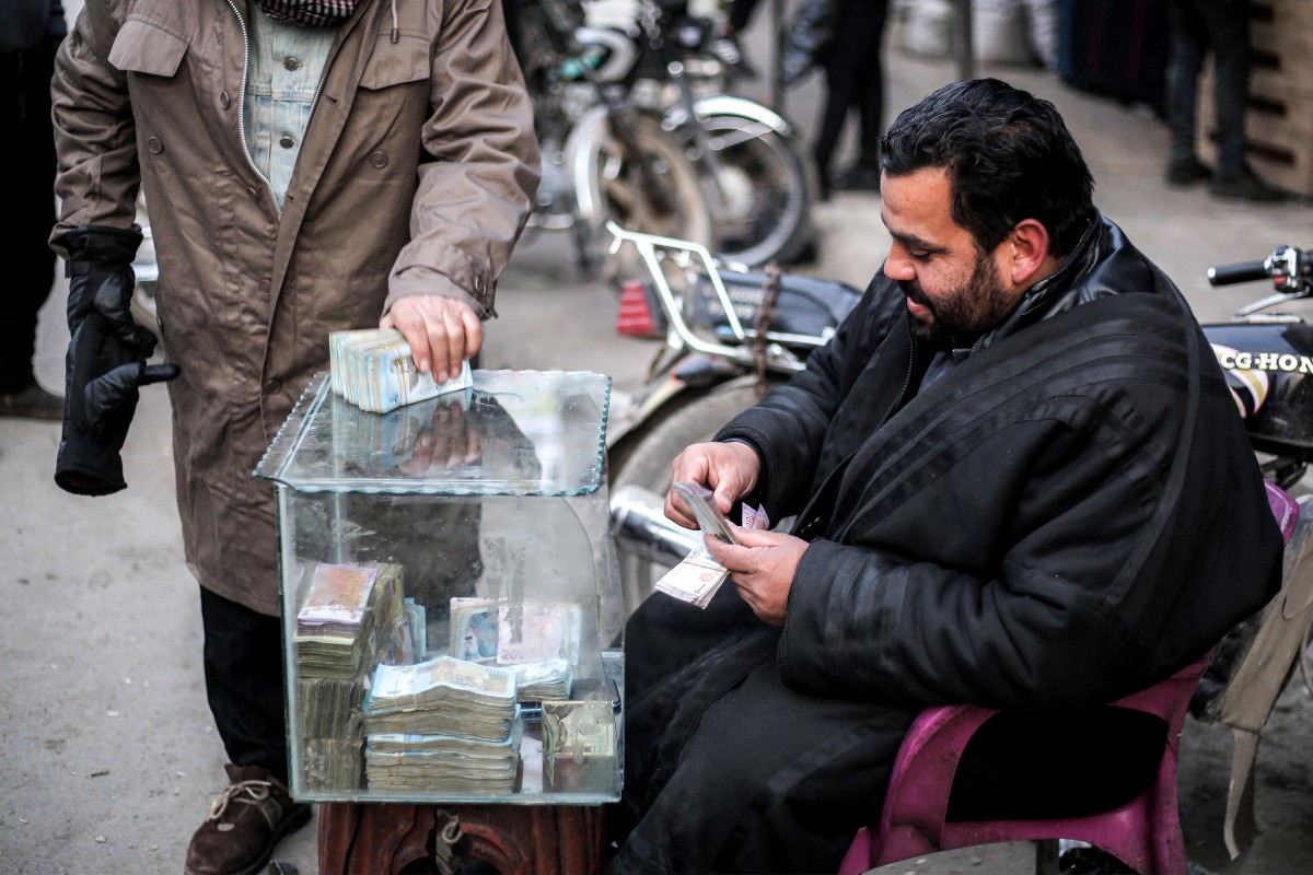 A currency trader sits at his stall at a market in the city of Manbij, currently controlled by the Turkish-backed Syrian National Army faction, in Syria's northern Aleppo province on January 4, 2025 (AFP)