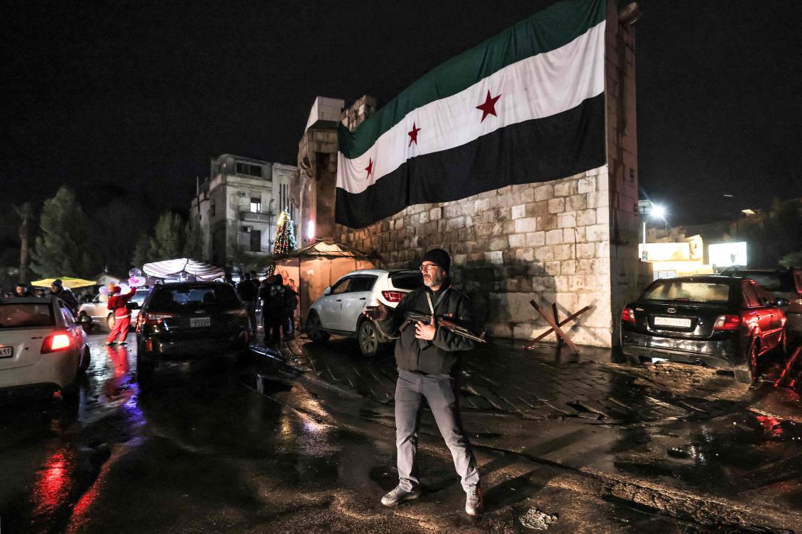 Above, armed local volunteers stand guard to protect their area by the old city walls of Damascus in the Bab Toma district on Dec. 29, 2024. (AFP)