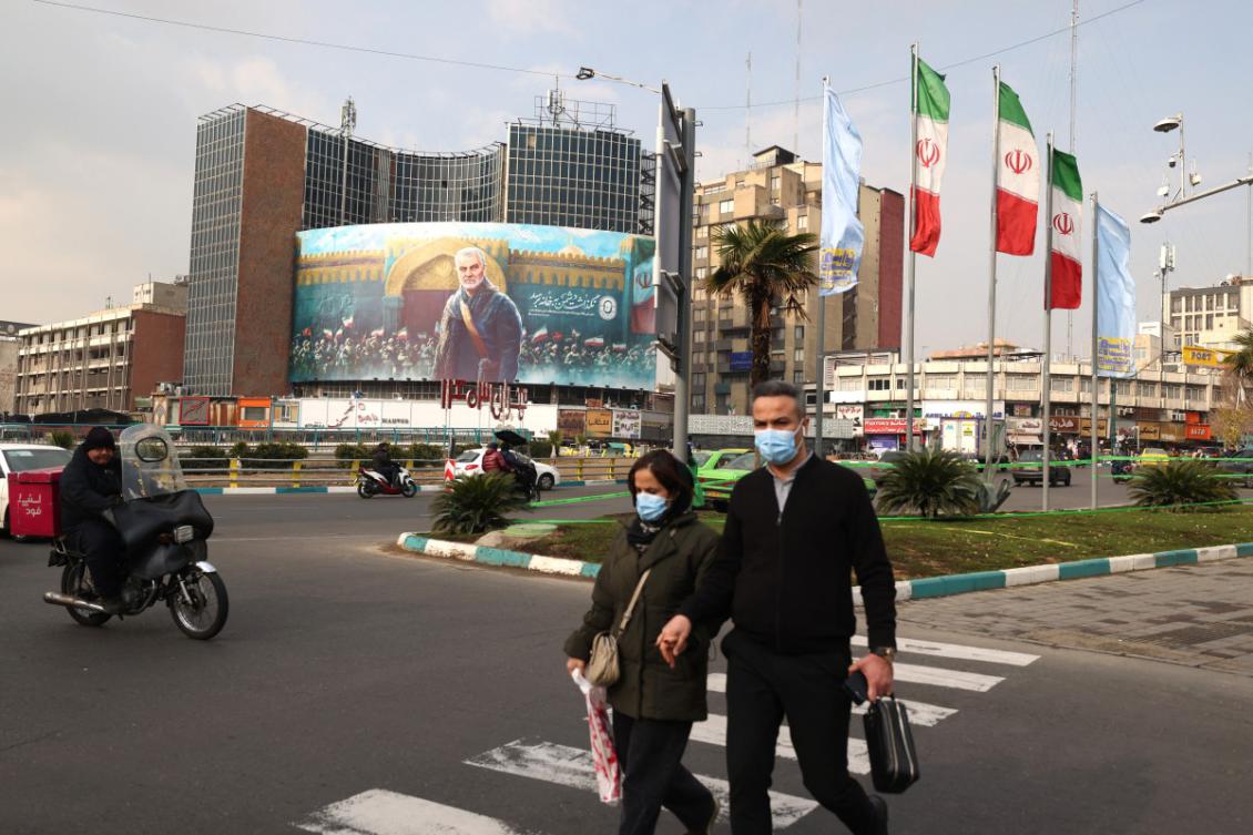 Iranian cross the street next to a billboard bearing the portrait of Iran's slain Revolutionary Guards commander Qasem Soleimani hangs on the side of a buildings overlooking a roundabout in Tehran on January 1, 2025. (File/AFP)