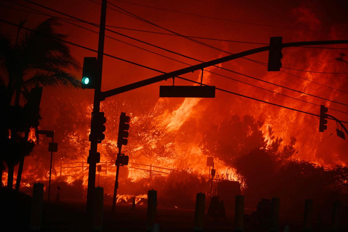 A fast-moving wildfire in a Los Angeles suburb burned buildings and sparked panic, with thousands ordered to evacuate January 7, 2025 as “life threatening” winds whipped the region. (AFP)