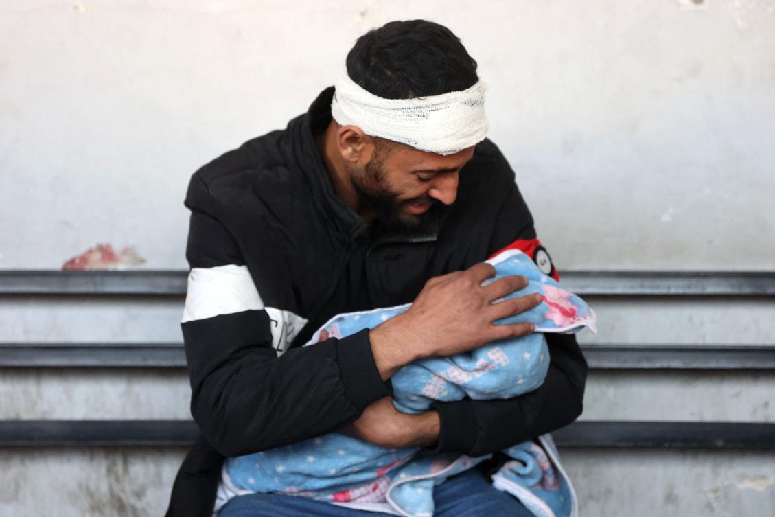 Palestinian Bilal Kallab cries as he holds the body of his 17-day-old baby Adnan, after he was killed during an Israeli strike in Gaza City, on January 8, 2025, at Ahli Arab hospital, also known as the Baptist hospital, amid the ongoing war in the Palestinian territory between Israel and Hamas. (AFP)