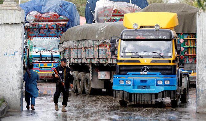An Afghan security guard stands while supply trucks carrying containers for export line at the Customhouse in Jalalabad, Afghanistan on May 14, 2018. (REUTERS)