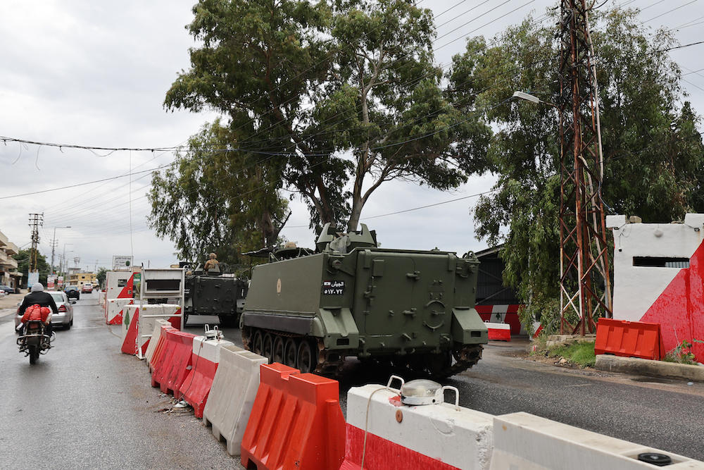 Above, Lebanese troops drive through a checkpoint south of the Litani River in Qasmiye near the port city of Tyre on Nov. 27, 2024, after a ceasefire between Israel and Hezbollah took effect. (AFP)