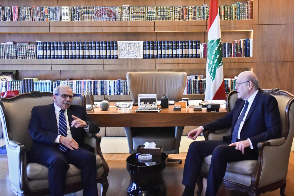 Lebanon’s new Prime Minister Nawaf Salam speaks with the country’s outgoing Prime Minister Najib Mikati during their meeting in Beirut on January 14, 2025. (AFP)