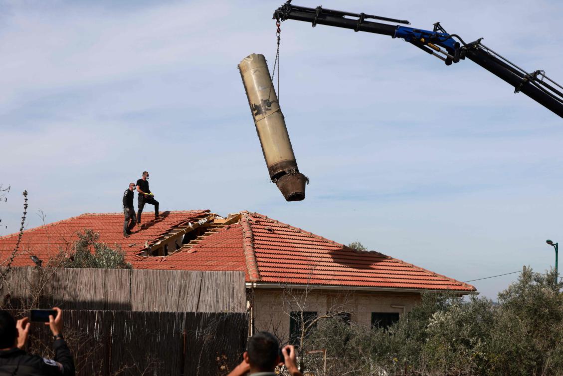Israeli security officers oversee the removal of part of a missile fired from Yemen a day earlier in the Israeli village of Mevo Beitar, west of Jerusalem on January 14, 2025. (AFP)