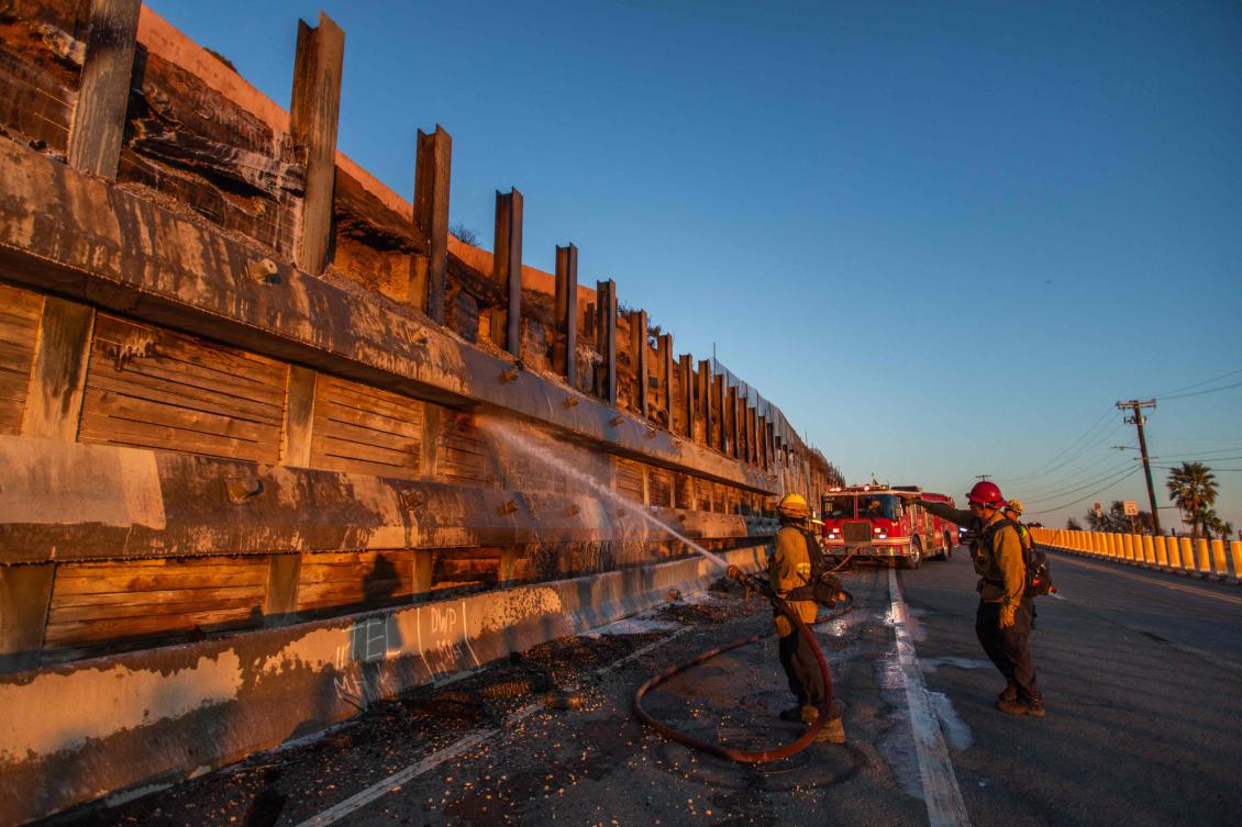 Fire fighters spray water and soap to eliminate hotspots in a wooden wall next to the Getty Vllage Museum on Jan. 12, 2025 in the Pacific Palisades neighborhood of Los Angeles, California. (AFP)