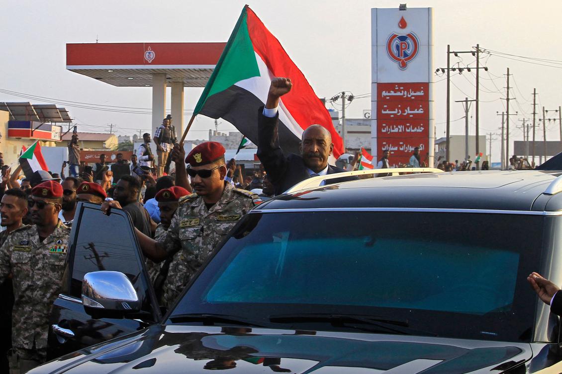 Sudan’s army chief Abdel Fattah Al-Burhan (C) gestures to people waiting to greet him along a street in Port Sudan, on Jan. 14, 2025. (AFP)